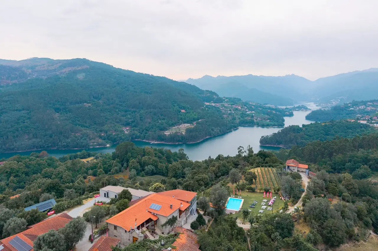Vista aérea da quinta no Gerês, com piscina e bandeiras Radar Tires, sobre a albufeira